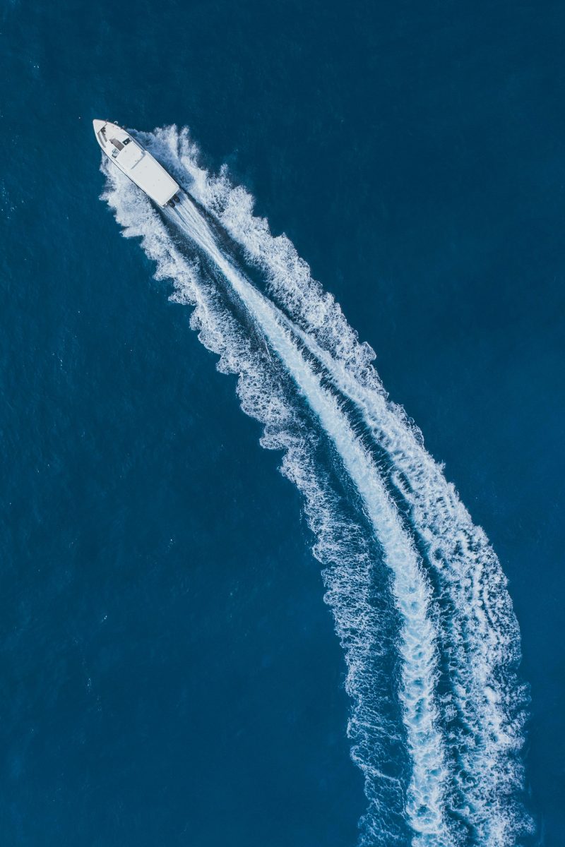 Aerial view of a private speedboat cutting a fast wake across the sea near Koh Samui