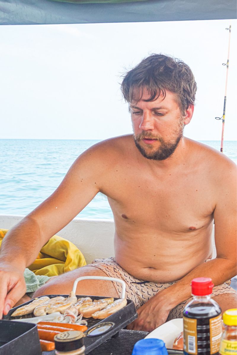 Man grilling food on a boat with ocean view