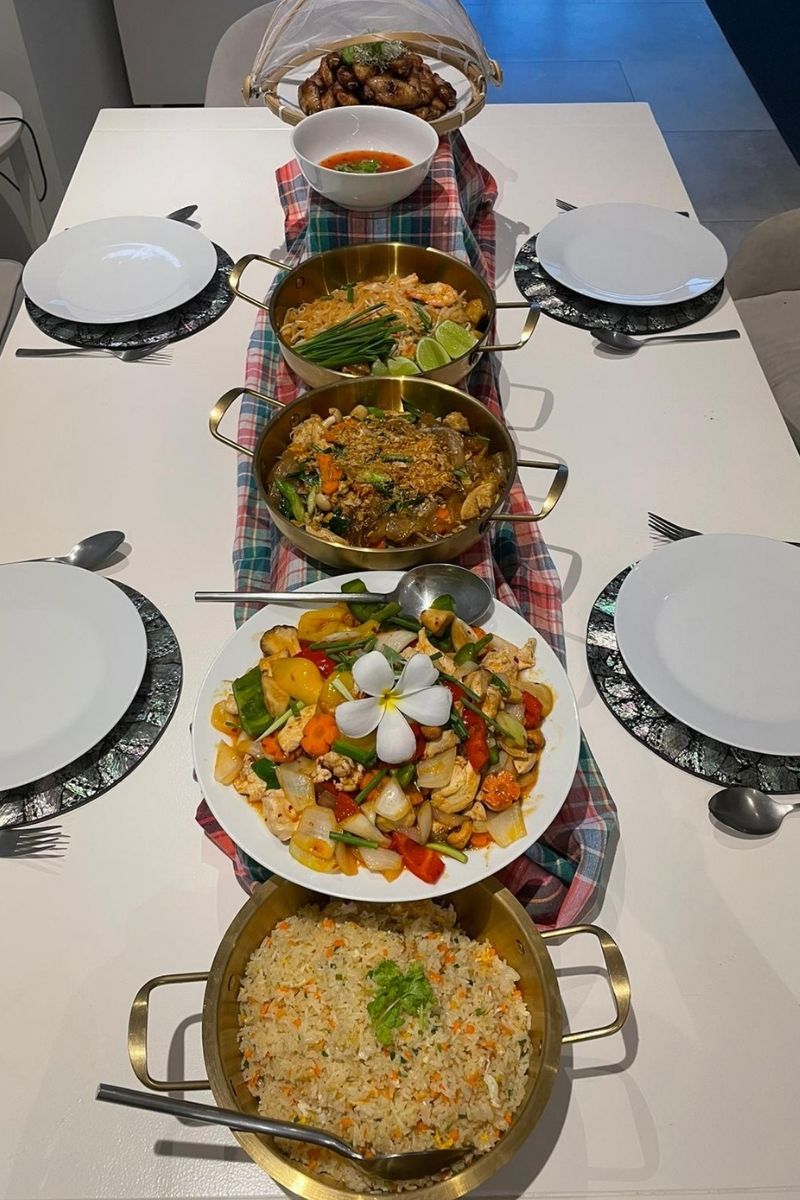 Dinner table set with various dishes including a stir-fry, rice, and soup.