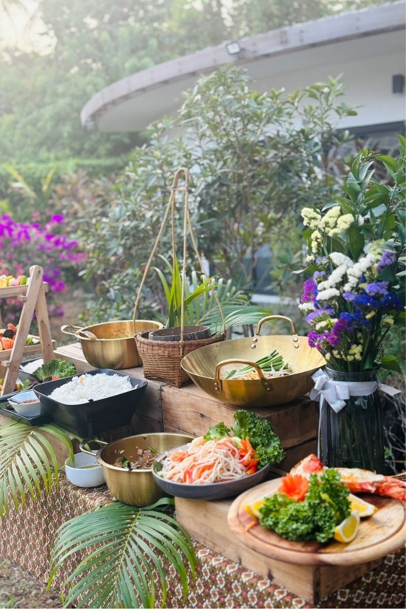 Outdoor setting with food preparation area, pots, and flowers in a garden.