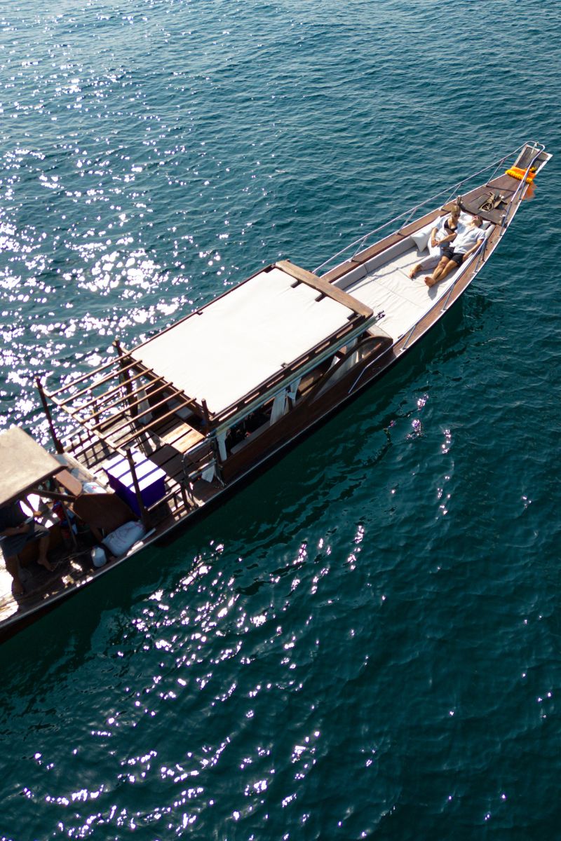 Luxury longtail boat on a body of water with people on board