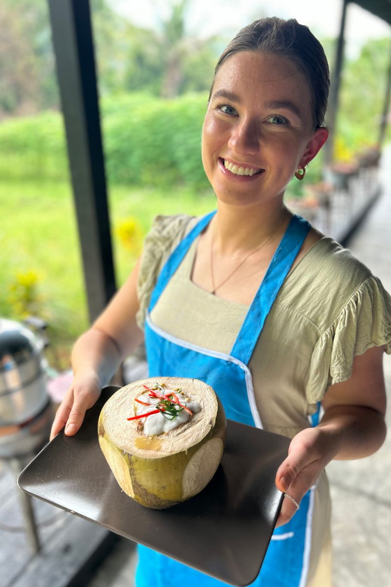 Person holding a dish with a tropical fruit dessert in an outdoor setting