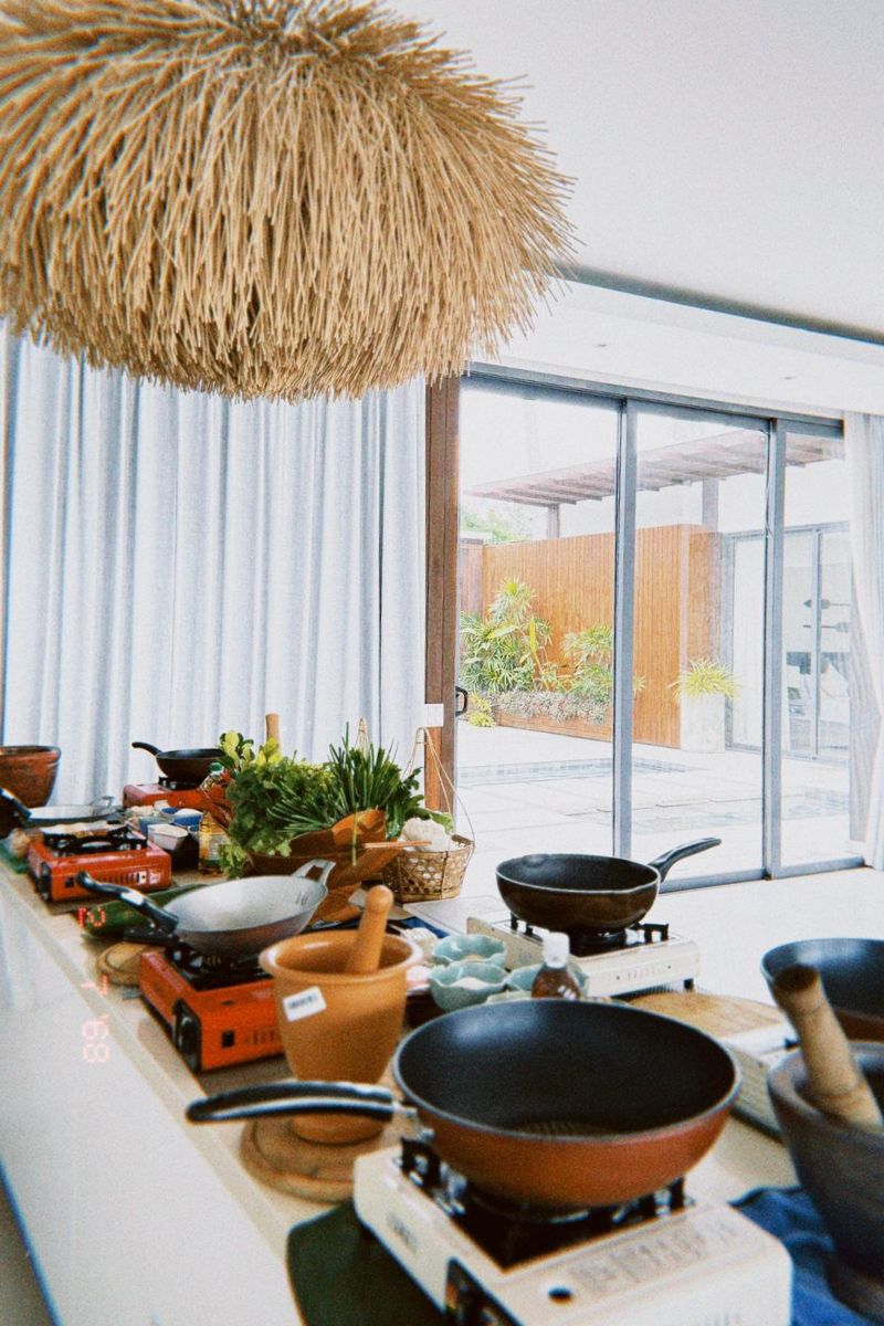 Kitchen setup with woks and cooking equipment on a counter.