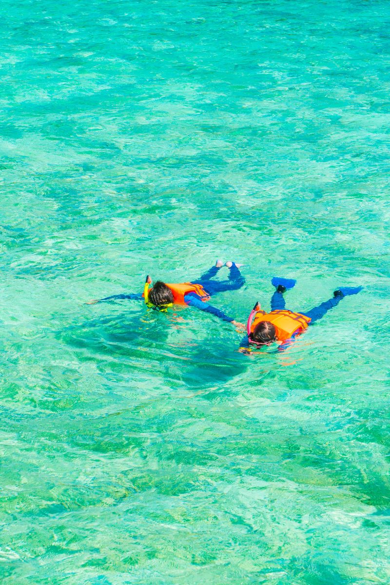 Two people snorkeling in clear turquoise water