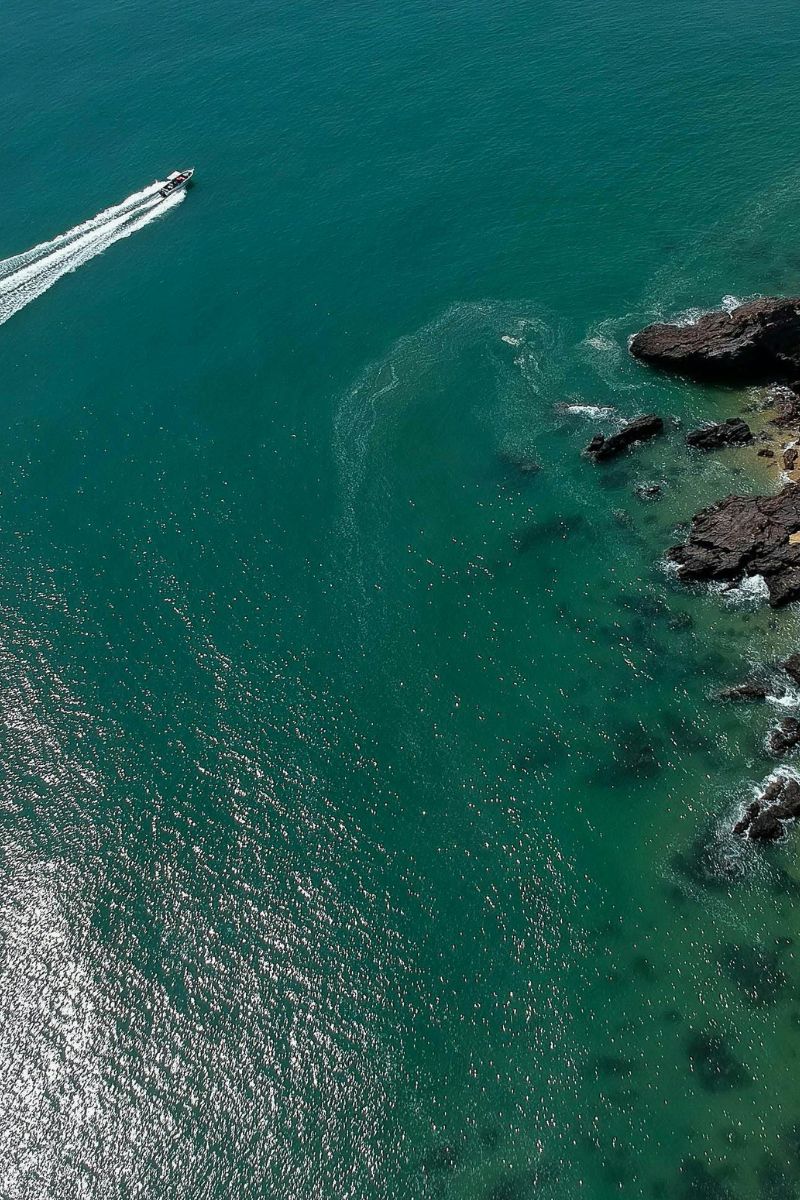 Boat navigating through turquoise waters near rocky coastline