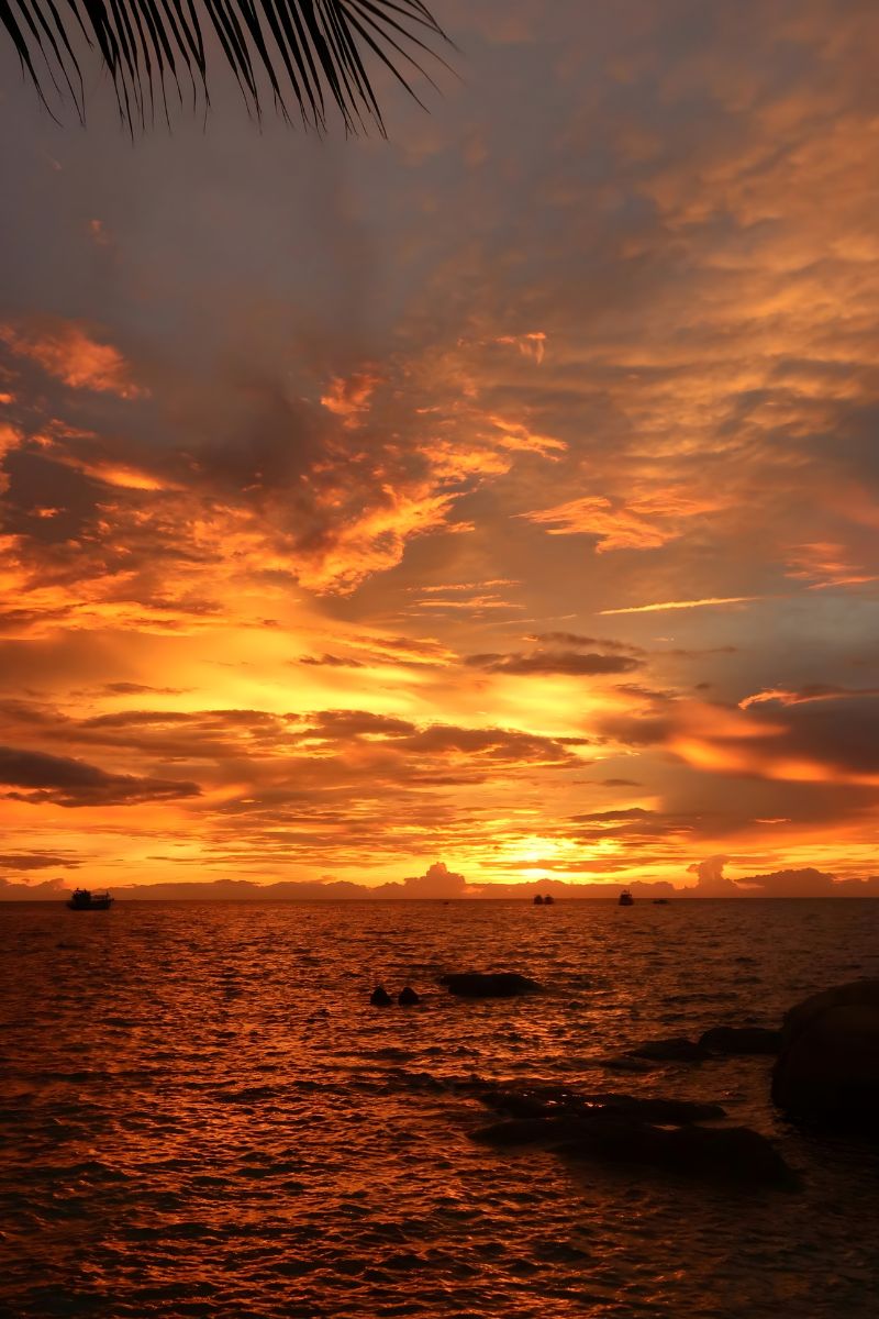 Sunset over water with orange and purple clouds