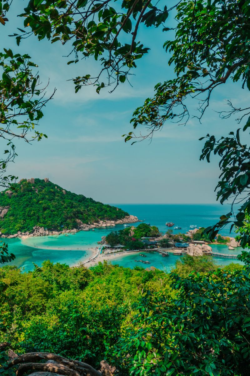 Scenic view of a tropical island with clear blue water and greenery.