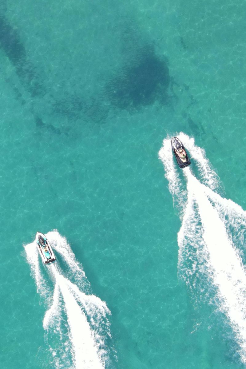 Two speedboats on a clear blue sea from an aerial view