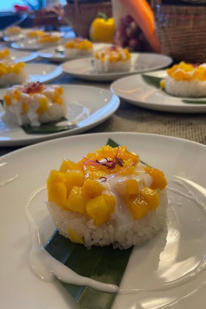 Mango dessert on a white plate with other similar desserts in the background