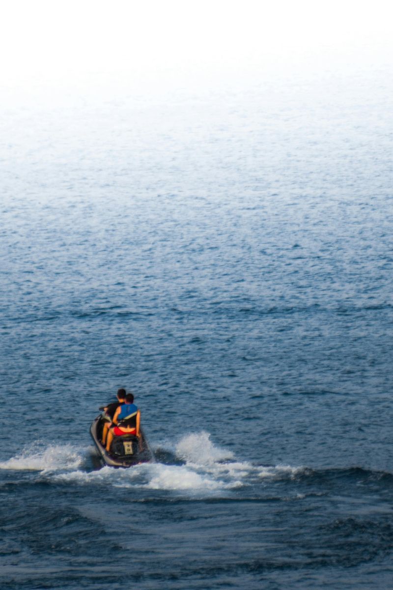 Person riding a jet ski on a calm blue ocean